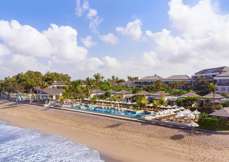 Bãi biển Seminyak buổi sáng trong mùa mưa, trời xanh nắng nhạt, vài đám mây trắng phía xa