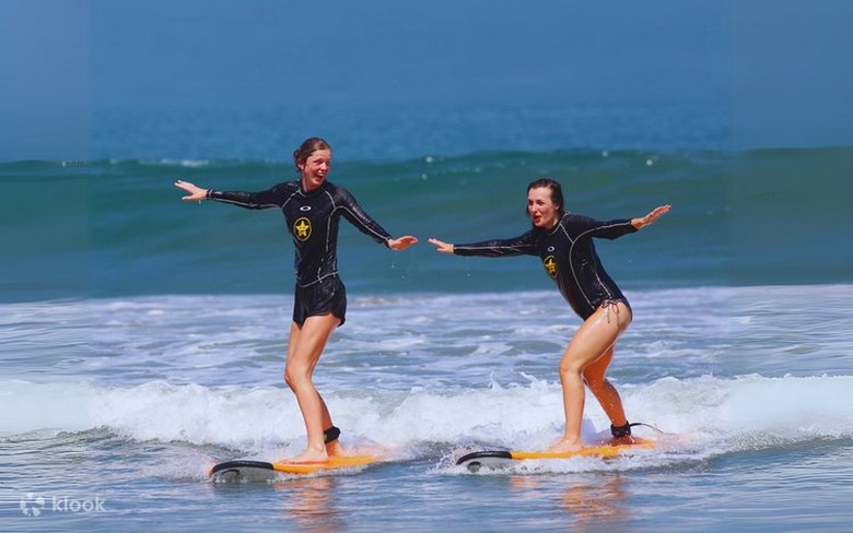 Học viên đang tập đứng trên ván surf cùng huấn luyện viên người Bali tại bãi Kuta