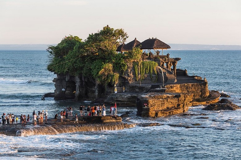 Khách du lịch mặc sarong truyền thống chuẩn bị vào tham quan đền Tanah Lot lúc hoàng hôn
