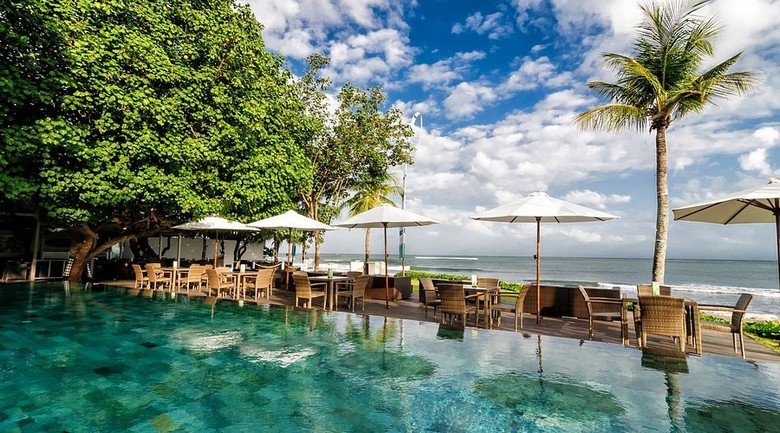 Khu vực hồ bơi ngoài trời của một resort 4 sao tại Kuta nhìn ra hướng biển buổi sáng sớm