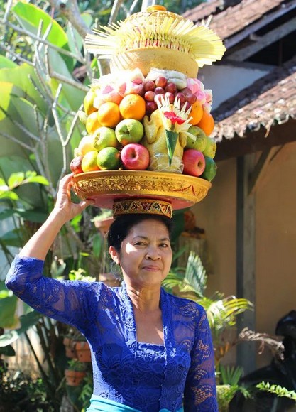 Lễ vật hoa, trái cây và nhang được người phụ nữ Bali dâng lên bàn thờ nhỏ trước cửa nhà vào buổi sáng