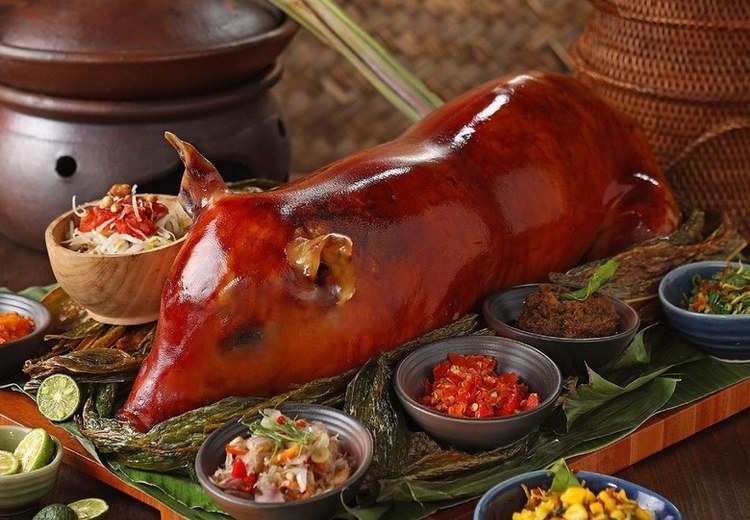 Babi Guling với da heo giòn vàng, được bày cùng rau và nước sốt đỏ tại Ibu Oka Ubud