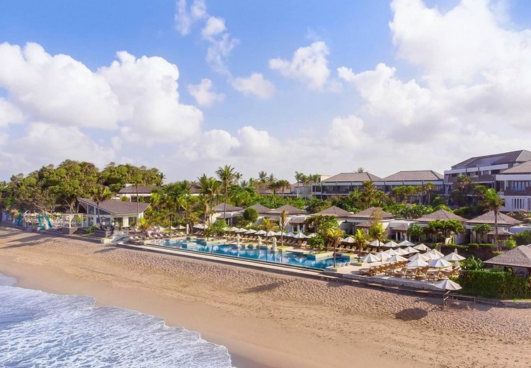 Bãi biển Seminyak buổi sáng trong mùa mưa, trời xanh nắng nhạt, vài đám mây trắng phía xa