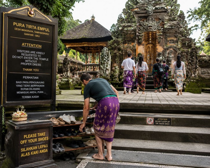 Du khách cởi giày trước khi vào điện thờ chính trong một ngôi đền tại Ubud, Bali