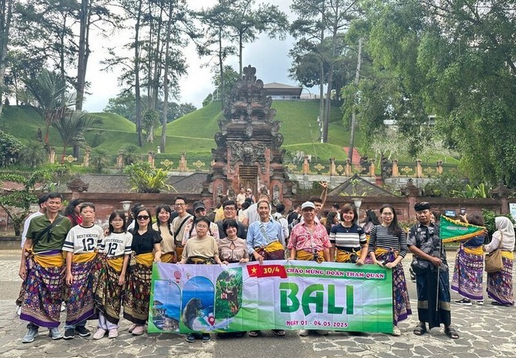Đoàn khách Việt tham quan đền Tanah Lot Bali lúc chiều tà, hướng dẫn viên đang thuyết minh
