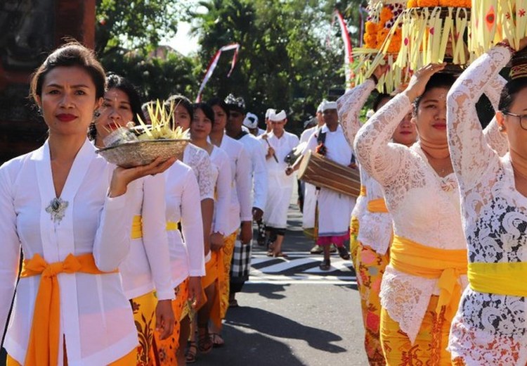 Đoàn rước lễ Odalan tại một ngôi đền làng Bali, phụ nữ mặc kebaya trắng đội lễ vật trên đầu