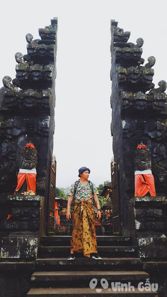 Du khách quấn sarong đứng trước cổng đền Bali