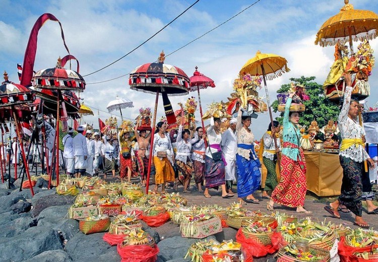Du khách quấn sarong đứng bên lề xem đoàn rước
