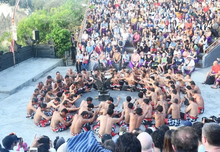 Gia đình khách du lịch ngồi xem múa Kecak tại sân khấu ngoài trời đền Uluwatu