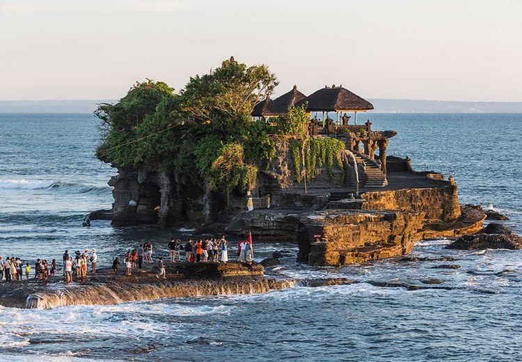 Khách mặc sarong truyền thống trước cổng đền Tanah Lot lúc hoàng hôn