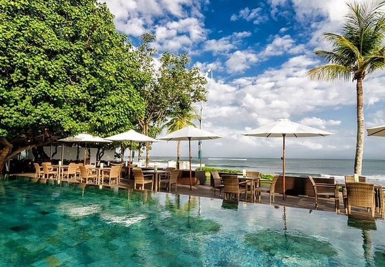 Khu vực hồ bơi ngoài trời của một resort 4 sao tại Kuta nhìn ra hướng biển buổi sáng sớm