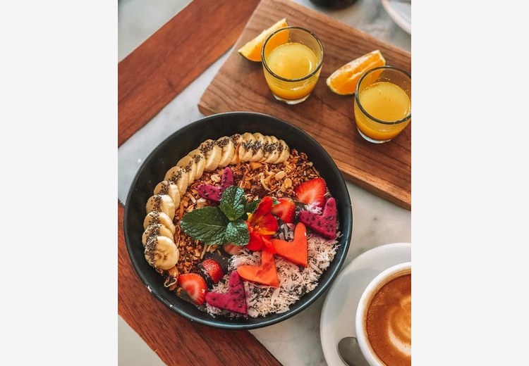 Ly smoothie bowl và granola chay tại một quán cà phê sáng tại Ubud với ánh nắng buổi sớm