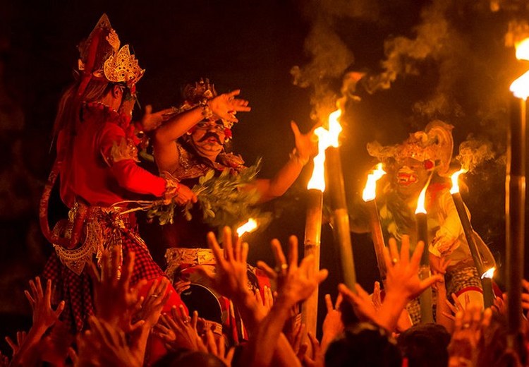 Nghệ nhân múa Kecak trong trang phục truyền thống với mặt nạ Ravana, ánh lửa phía sau