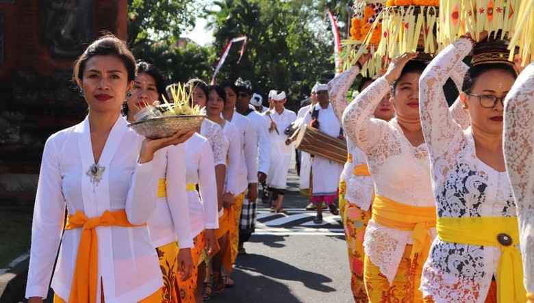 Đoàn rước lễ Odalan tại một ngôi đền làng Bali, phụ nữ mặc kebaya trắng đội lễ vật trên đầu