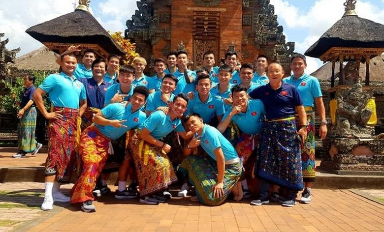 Du khách Việt Nam đang mặc sarong truyền thống trước khi vào đền Besakih — minh họa phong tục văn hóa cần tuân thủ khi tham quan đền ở Bali