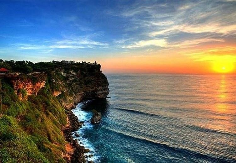 Vách đá đền Uluwatu nhìn từ xa, sóng biển đập vào chân đá bên dưới